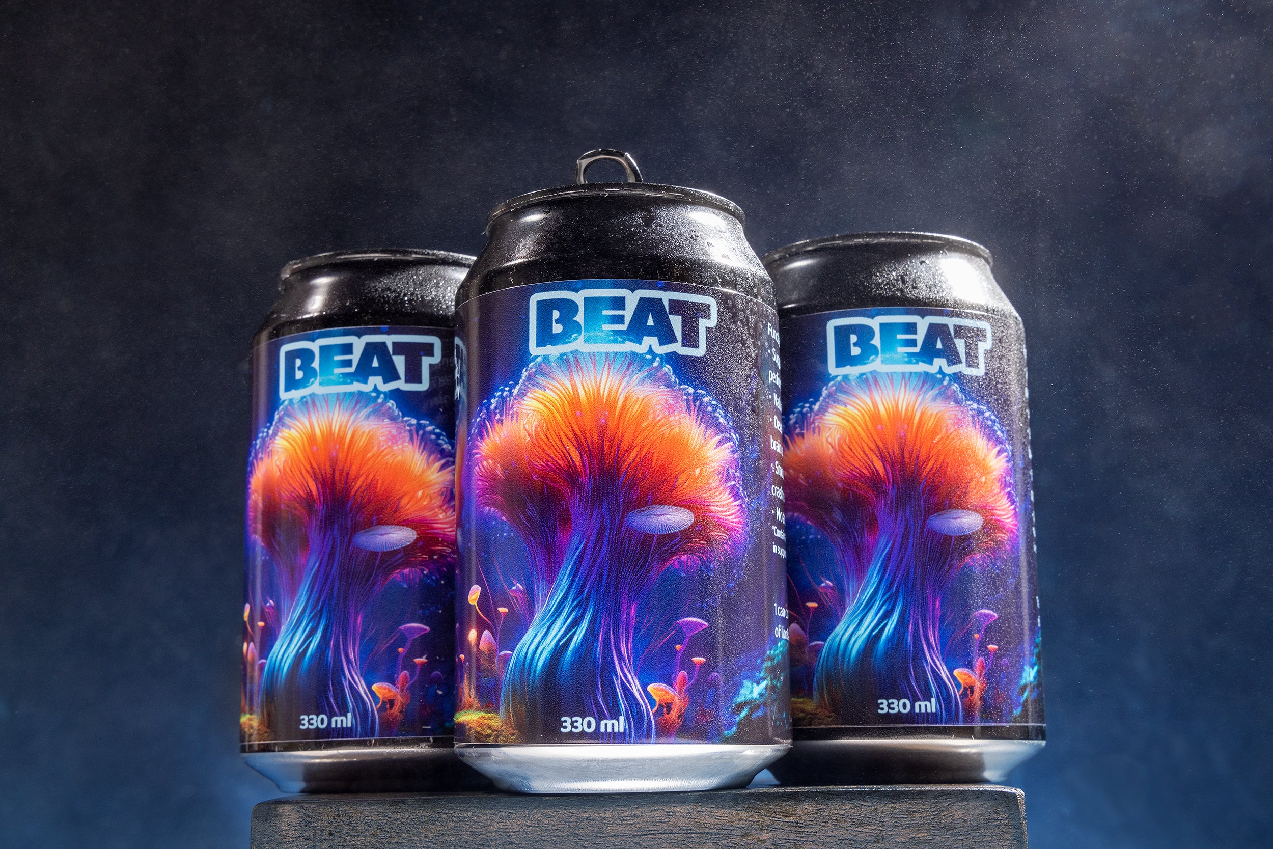 Three BEAT cans with colorful designs on a dark background